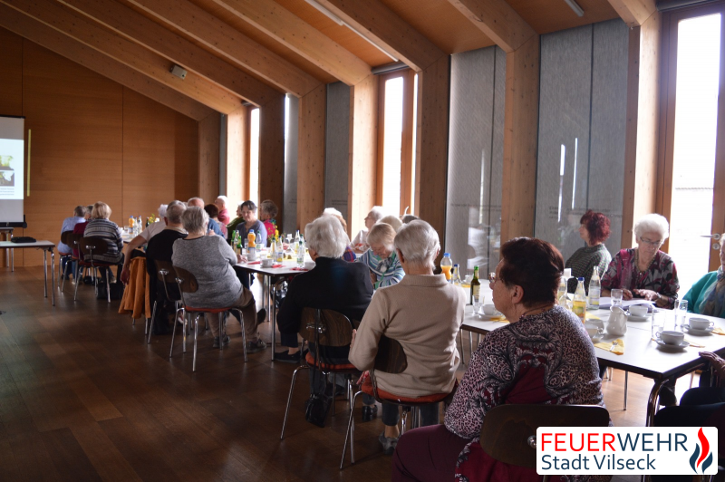 Seniorinnen und Senioren hören dem Referenten zu